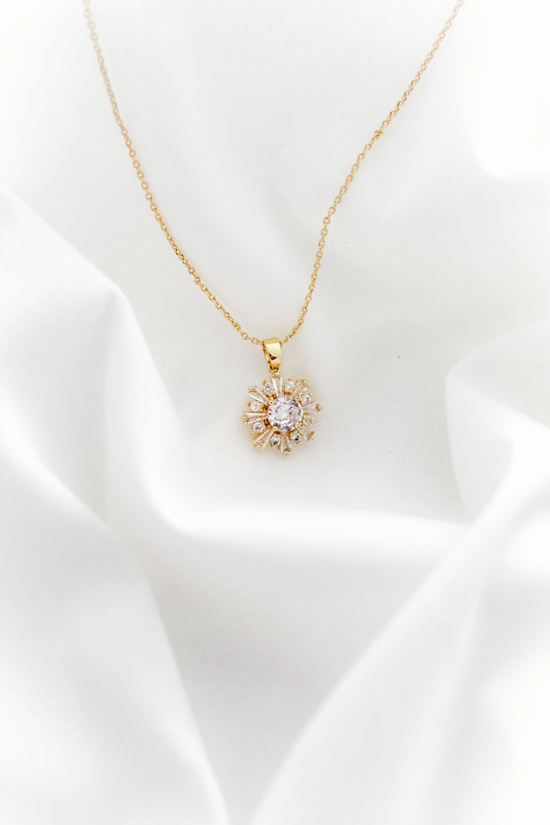Delicate gold pendant on cream satin fabric